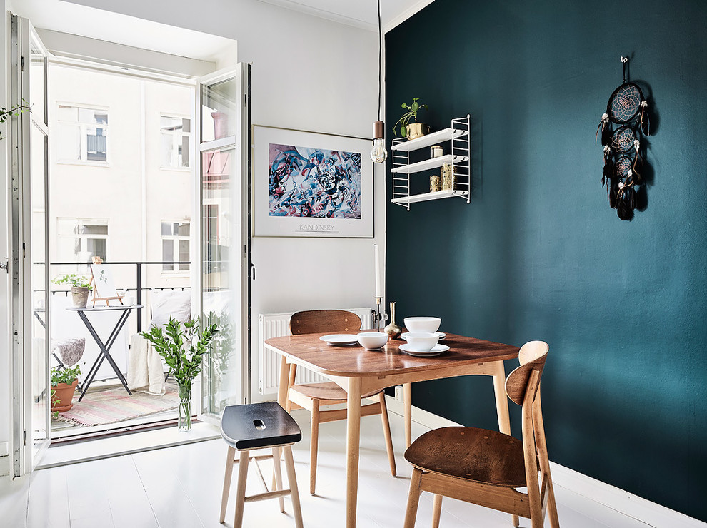 На фото: столовая среднего размера в скандинавском стиле с синими стенами и деревянным полом без камина с