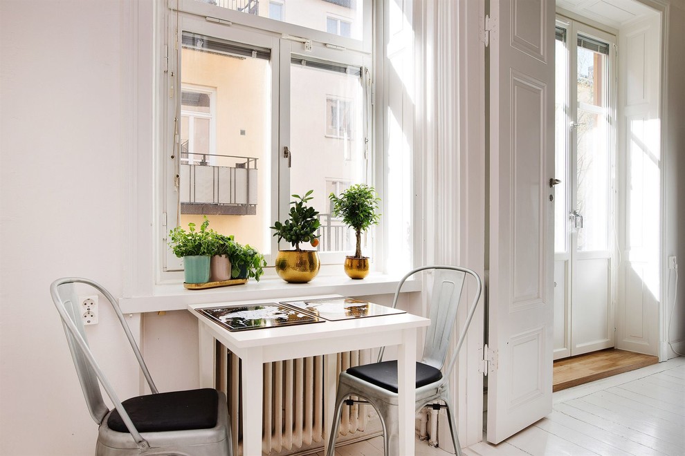 Ispirazione per una sala da pranzo aperta verso la cucina scandinava di medie dimensioni con pareti bianche, pavimento in legno verniciato e nessun camino