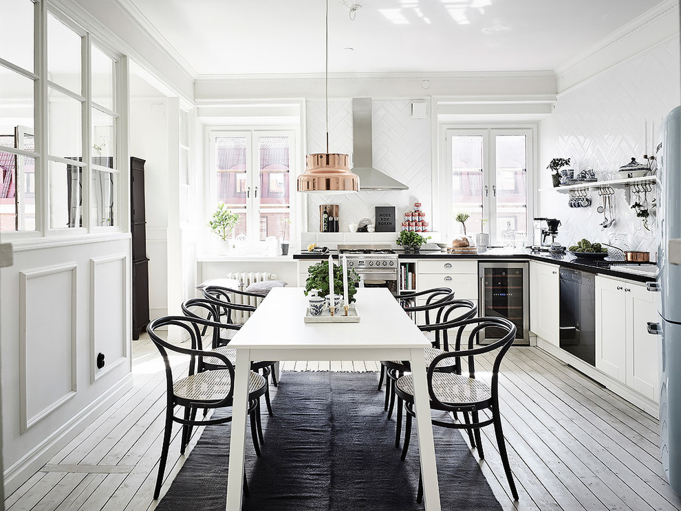 Пример оригинального дизайна: кухня-столовая среднего размера в скандинавском стиле с белыми стенами и светлым паркетным полом без камина