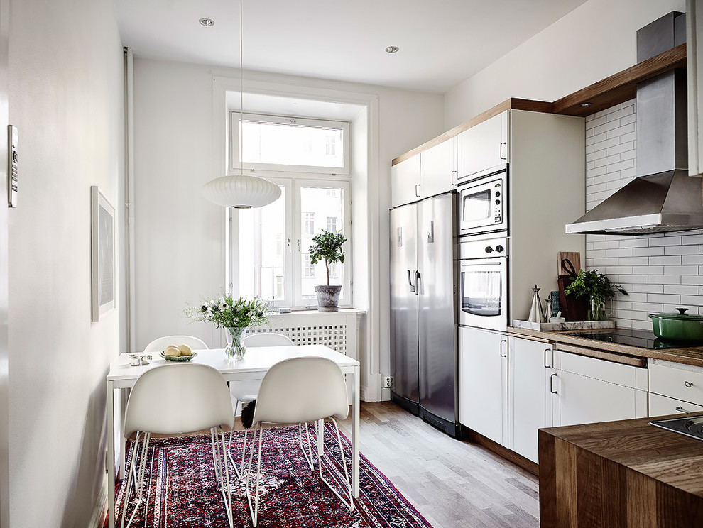 Medium sized scandinavian kitchen/dining room in Gothenburg with white walls, light hardwood flooring and no fireplace.