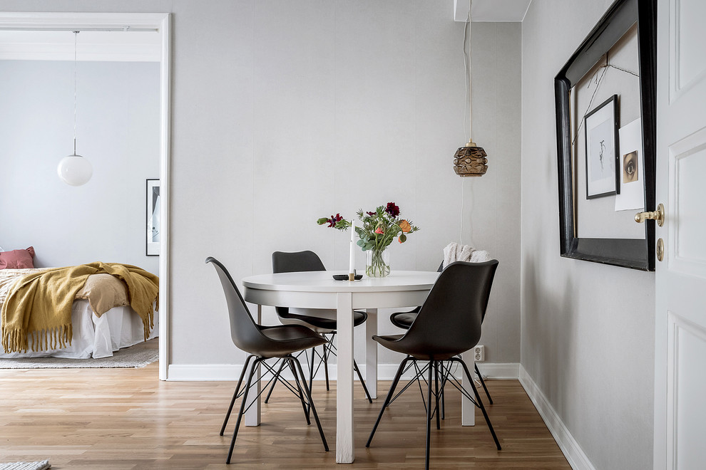 Immagine di una sala da pranzo nordica con pareti grigie, pavimento in legno massello medio e pavimento marrone