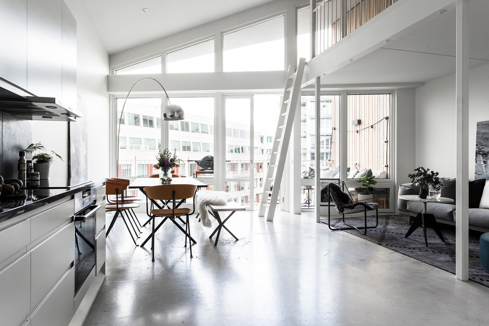 Свежая идея для дизайна: столовая в стиле модернизм с белыми стенами, бетонным полом и серым полом без камина - отличное фото интерьера