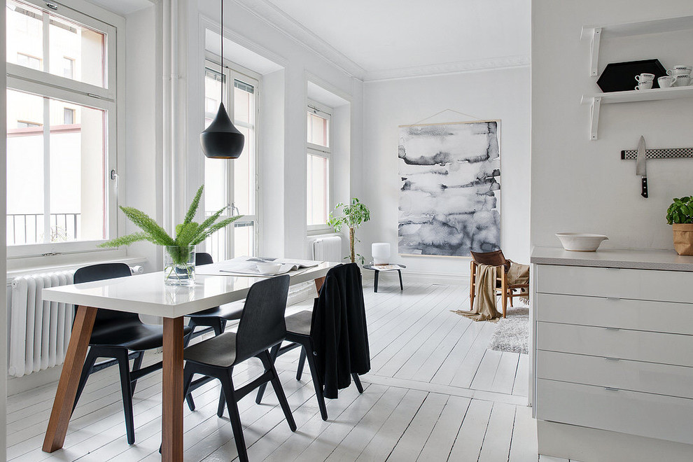 Modelo de comedor de cocina nórdico grande con paredes blancas y suelo de madera pintada