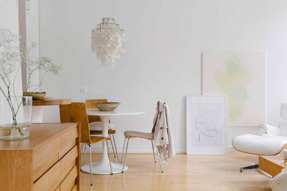 Esempio di una sala da pranzo aperta verso il soggiorno nordica di medie dimensioni con pareti bianche, parquet chiaro e pavimento beige