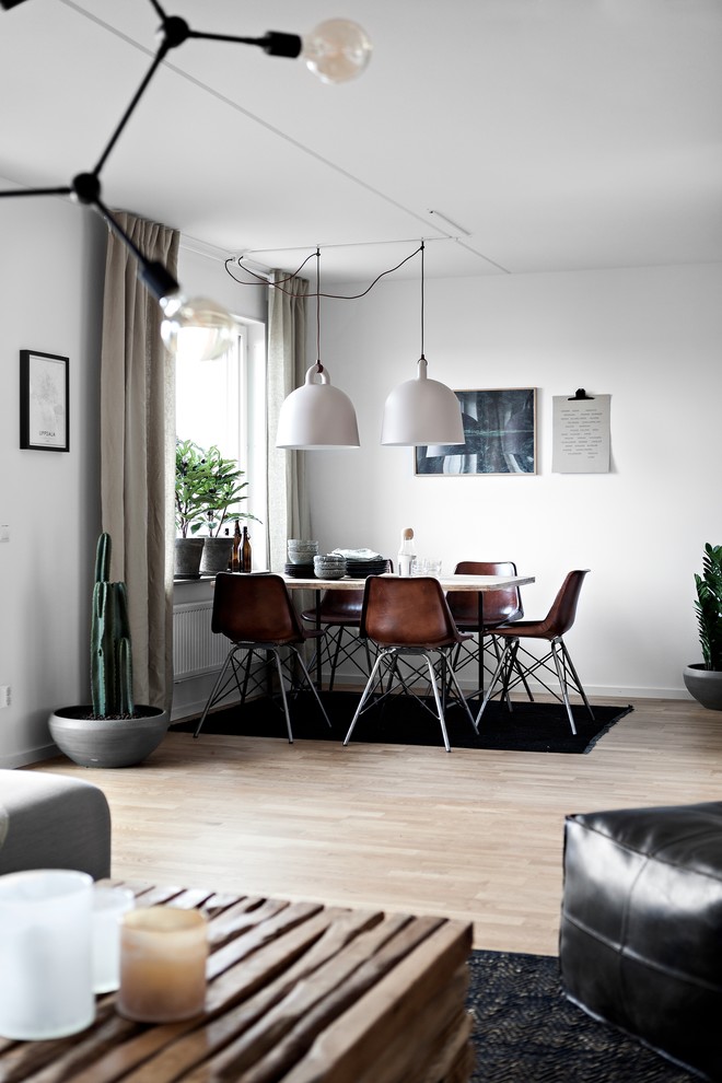 Photo of a large scandinavian open plan dining room in Gothenburg with white walls, light hardwood flooring, no fireplace and brown floors.