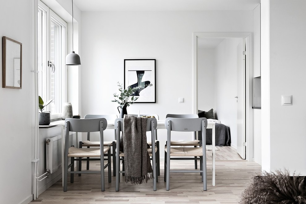 Inspiration för en minimalistisk matplats med öppen planlösning, med vita väggar, ljust trägolv och beiget golv