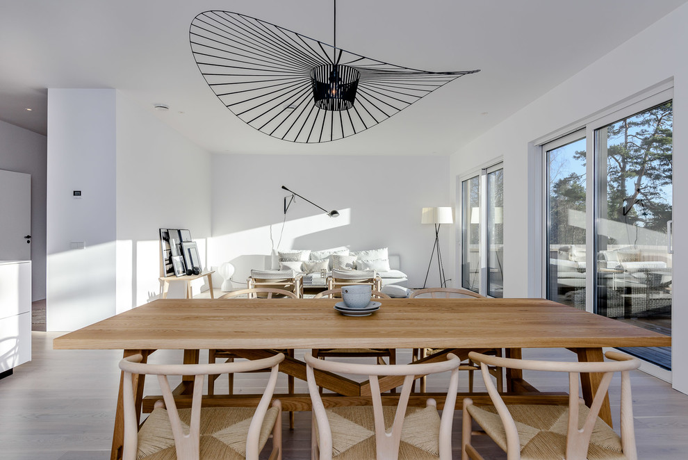 This is an example of a scandinavian dining room in Stockholm with feature lighting.