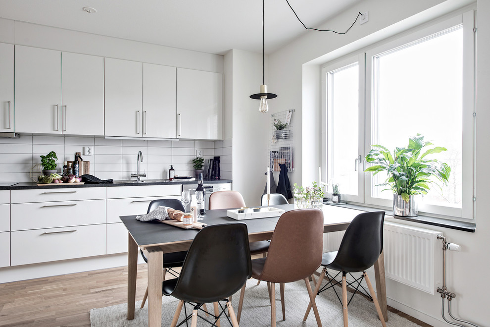 Ejemplo de comedor de cocina nórdico con paredes blancas, suelo de madera clara y suelo beige