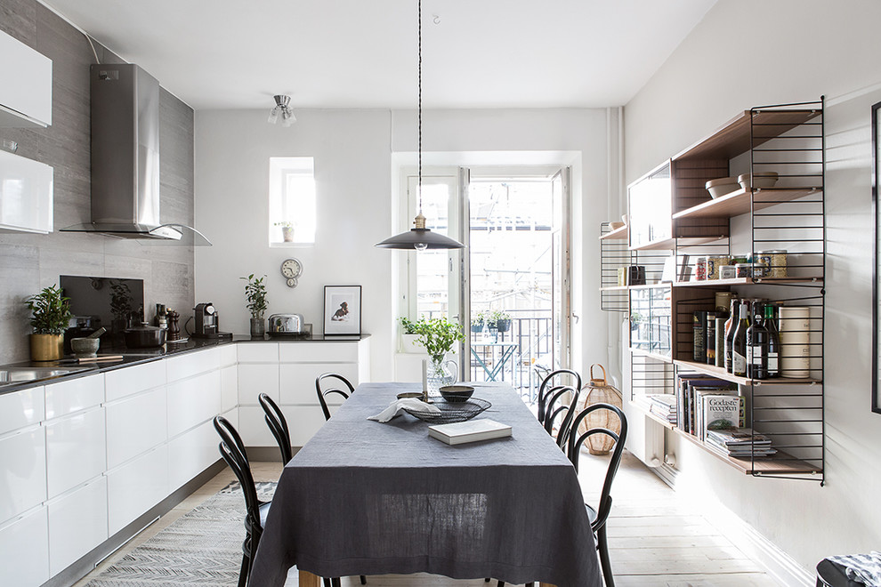 Источник вдохновения для домашнего уюта: кухня-столовая среднего размера в скандинавском стиле с белыми стенами и светлым паркетным полом без камина