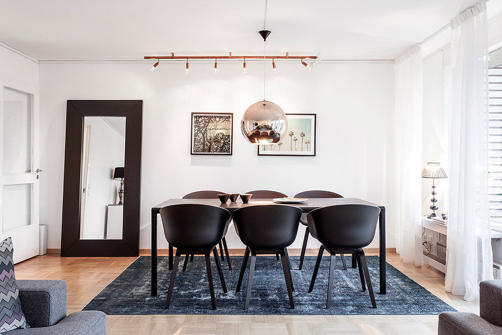 Photo of a contemporary open plan dining room in Gothenburg with light hardwood flooring, no fireplace, white walls and brown floors.