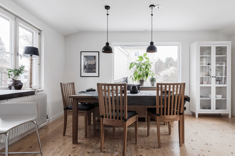 Inspiration for a medium sized scandi dining room in Stockholm with white walls, medium hardwood flooring and brown floors.