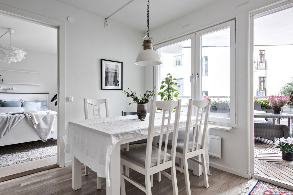 Foto på en minimalistisk matplats, med vita väggar, ljust trägolv och brunt golv