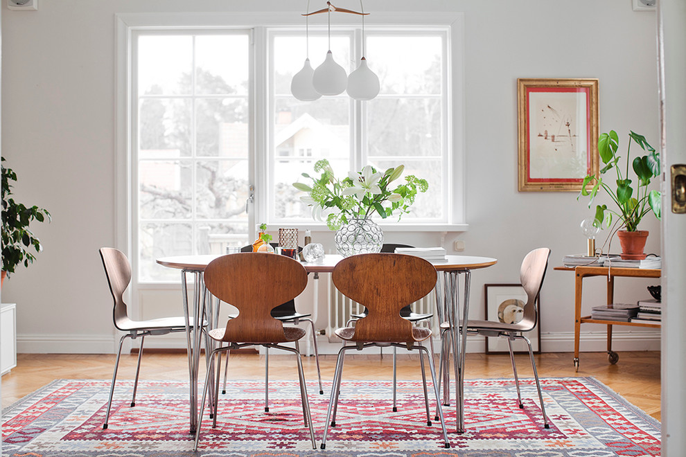 Inspiration for a mid-sized scandinavian medium tone wood floor dining room remodel in Stockholm with white walls