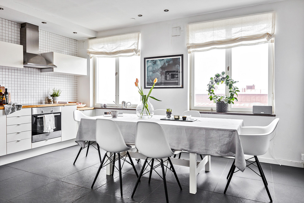 Kitchen/dining room combo - mid-sized scandinavian slate floor and gray floor kitchen/dining room combo idea in Gothenburg with white walls