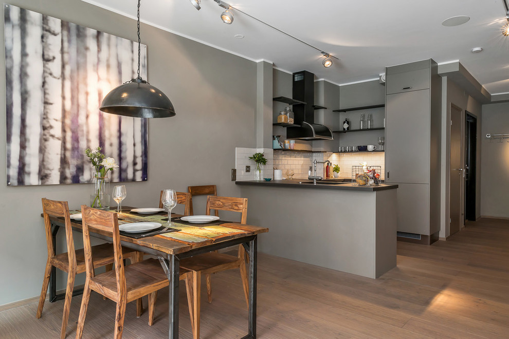 Example of a mid-sized trendy medium tone wood floor kitchen/dining room combo design in Stockholm with gray walls and no fireplace