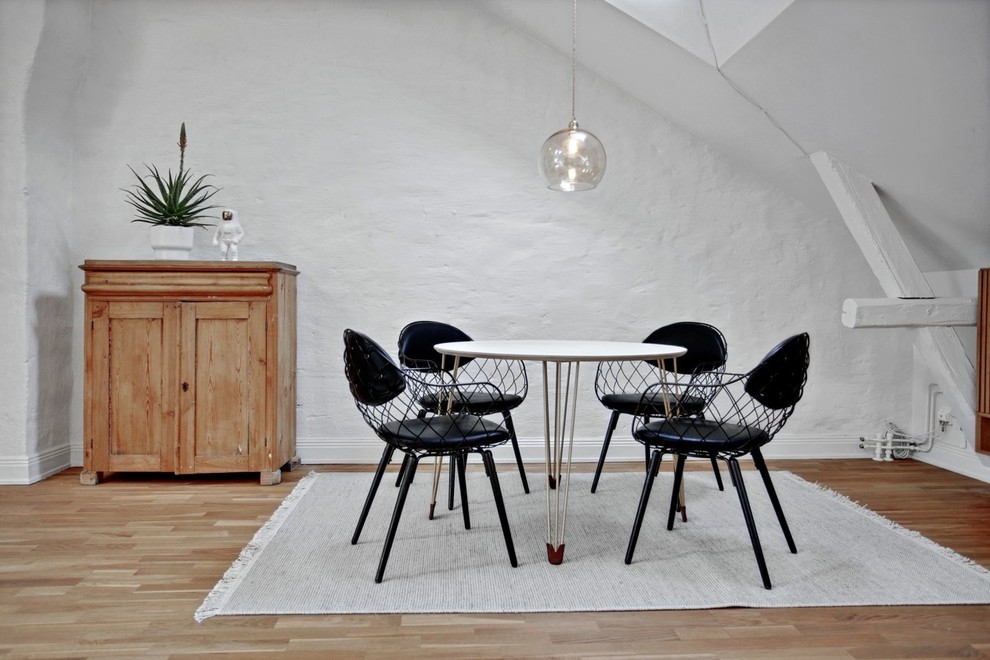 Exempel på en mellanstor minimalistisk separat matplats, med vita väggar och ljust trägolv