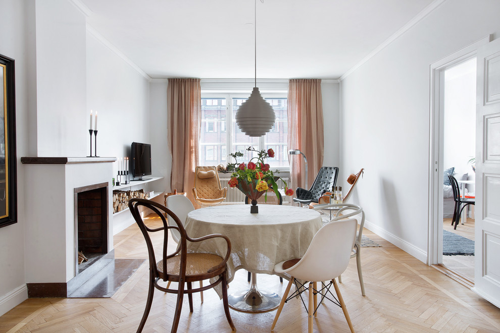 Exemple d'une salle à manger scandinave de taille moyenne avec un mur blanc, un sol en bois brun et une cheminée standard.