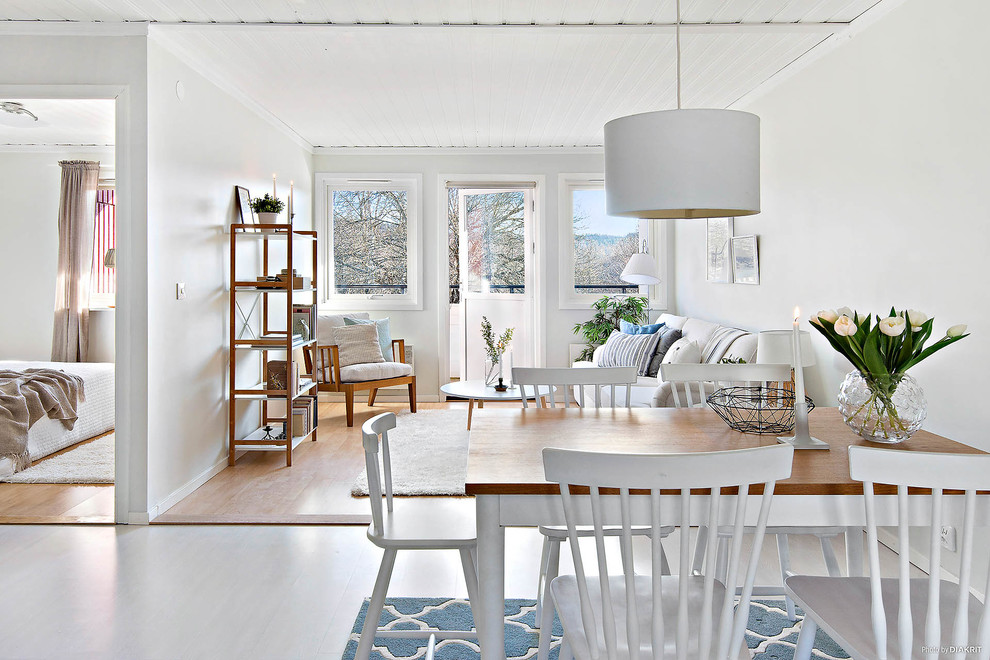 Пример оригинального дизайна: гостиная-столовая среднего размера в скандинавском стиле с белыми стенами и светлым паркетным полом