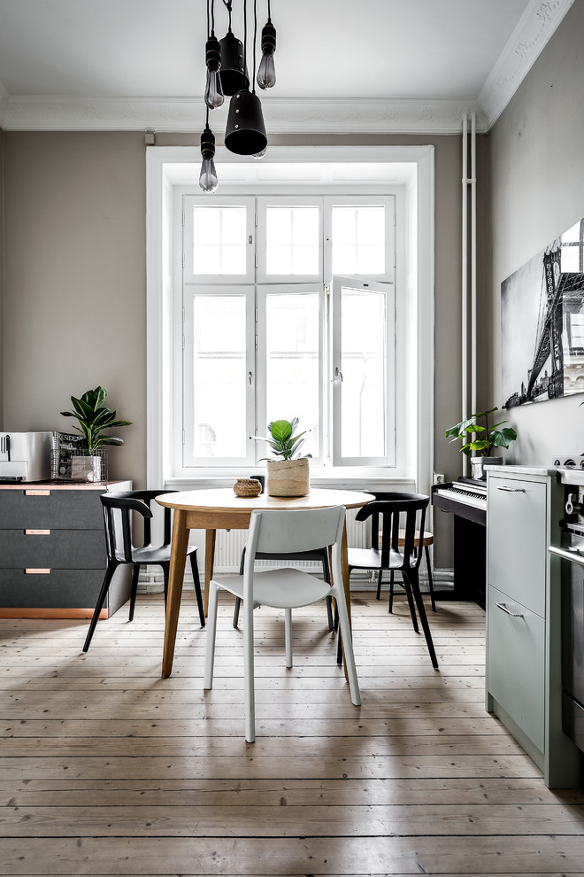Mid-sized danish light wood floor dining room photo in Stockholm with gray walls