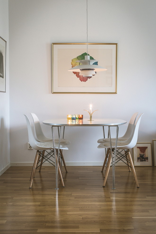 Foto di una sala da pranzo contemporanea con pareti bianche, pavimento in legno massello medio e pavimento marrone