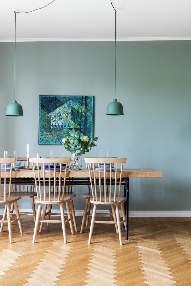 Medium sized scandinavian dining room in Stockholm with green walls, medium hardwood flooring, no fireplace and brown floors.