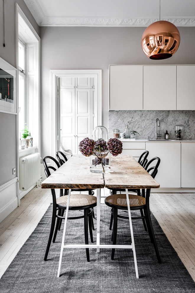 Ejemplo de comedor nórdico con paredes grises, suelo de madera clara y suelo beige