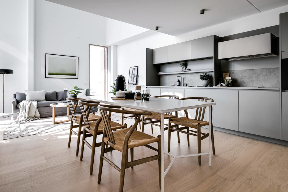 Exemple d'une salle à manger ouverte sur la cuisine scandinave de taille moyenne avec un mur blanc, un sol beige et parquet clair.
