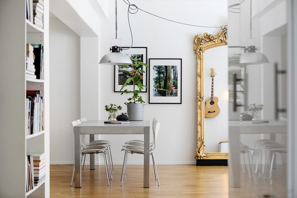 Immagine di una sala da pranzo scandinava con pareti bianche, parquet chiaro e pavimento marrone