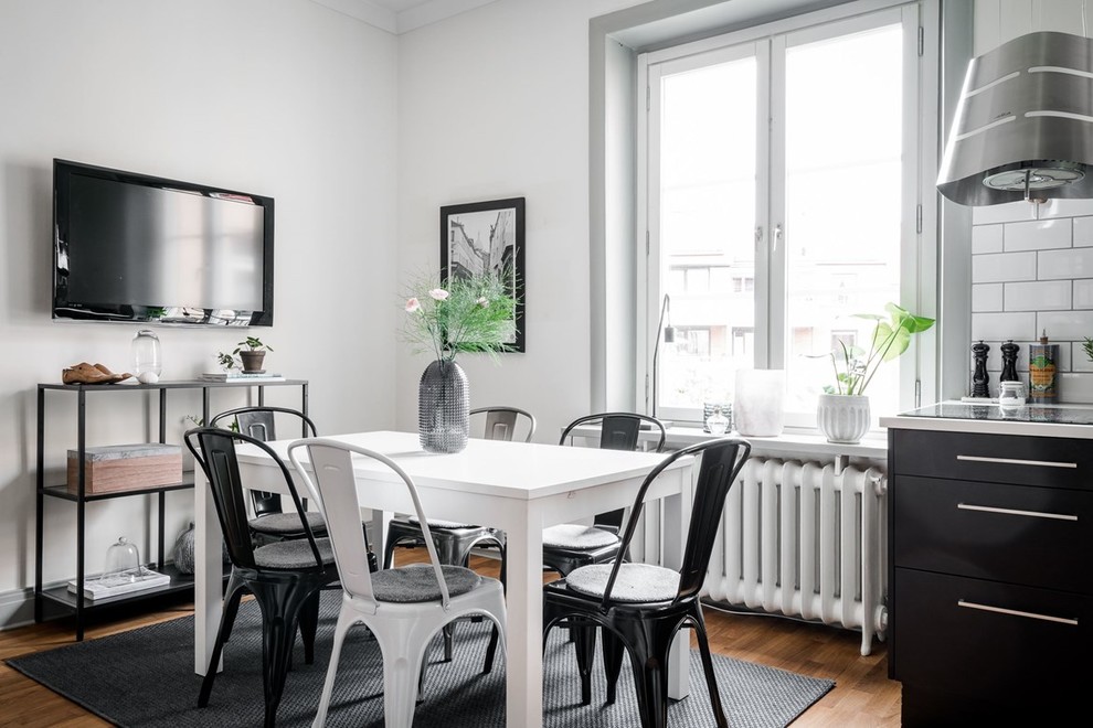 This is an example of a medium sized industrial dining room in Gothenburg with white walls and medium hardwood flooring.