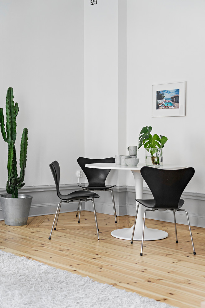 Inspiration for a scandi dining room in Stockholm with white walls, light hardwood flooring and beige floors.