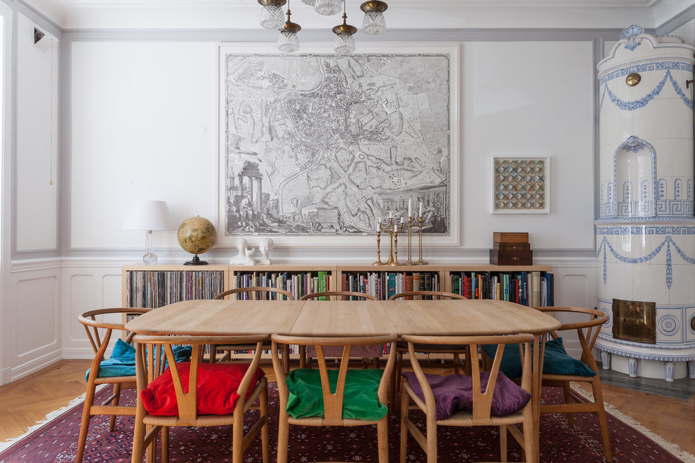 Источник вдохновения для домашнего уюта: отдельная столовая среднего размера в скандинавском стиле с белыми стенами, светлым паркетным полом и угловым камином