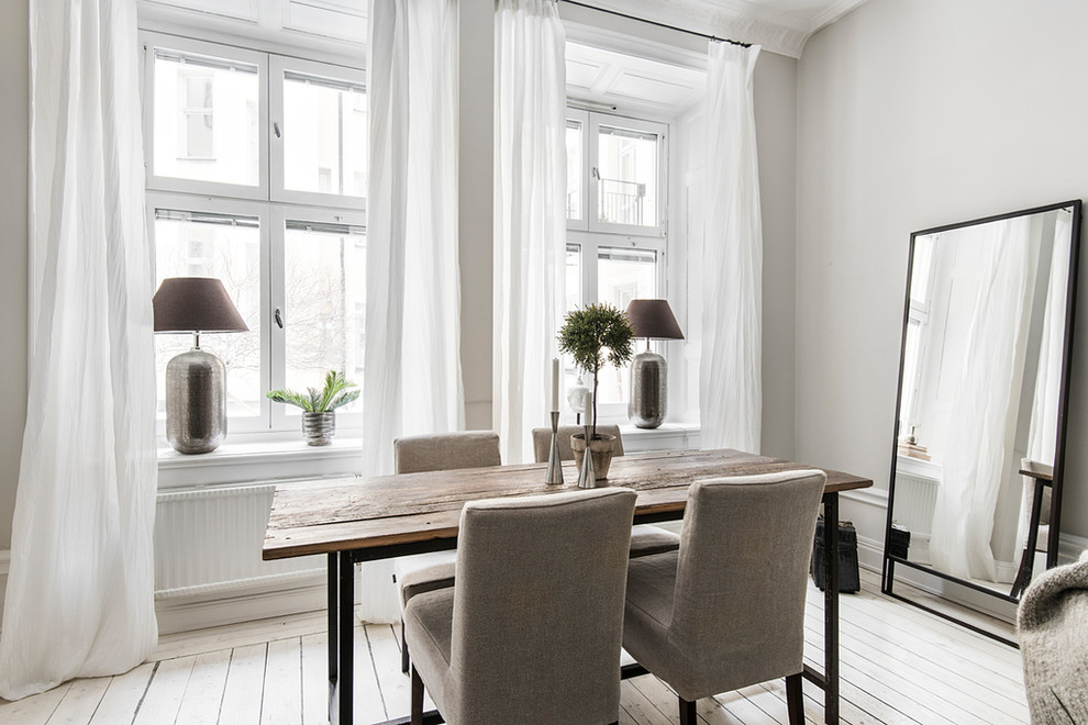 Skandinavisches Esszimmer mit grauer Wandfarbe, gebeiztem Holzboden und weißem Boden in Stockholm