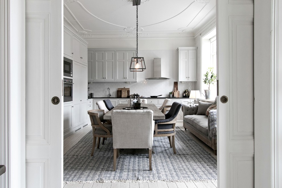 Foto på ett stort minimalistiskt kök med matplats, med vita väggar, ljust trägolv och beiget golv