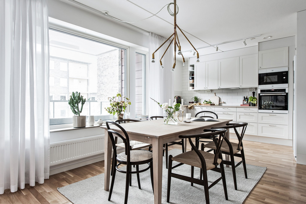 Bild på ett mellanstort skandinaviskt kök med matplats, med vita väggar, mellanmörkt trägolv och beiget golv