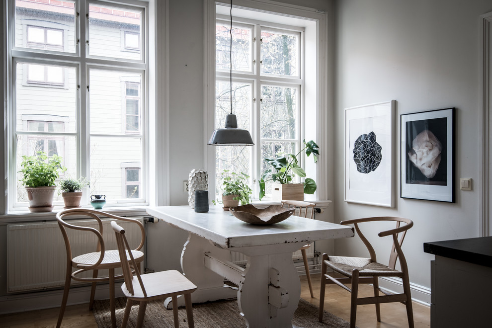 Свежая идея для дизайна: столовая в скандинавском стиле с белыми стенами, светлым паркетным полом и коричневым полом - отличное фото интерьера