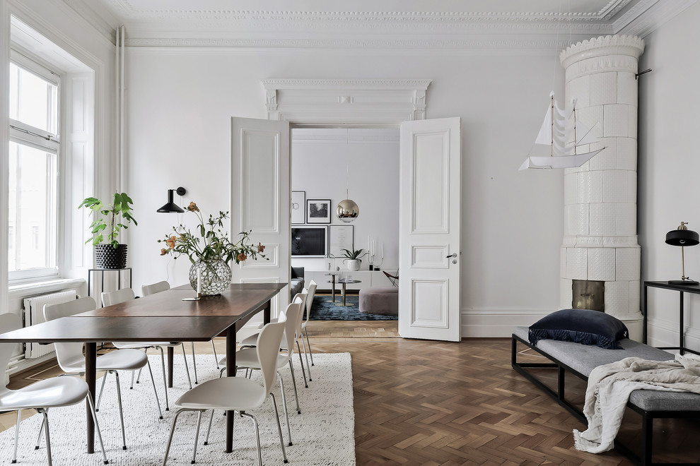 Стильный дизайн: столовая в скандинавском стиле с белыми стенами и паркетным полом среднего тона - последний тренд