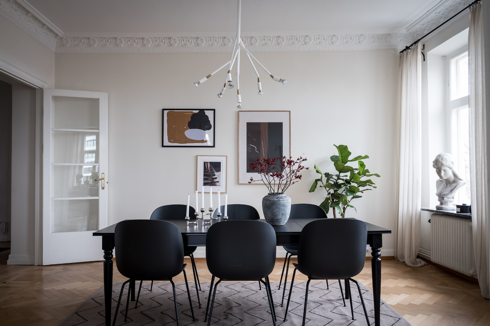 Scandinavian enclosed dining room in Gothenburg with beige walls, light hardwood flooring and beige floors.