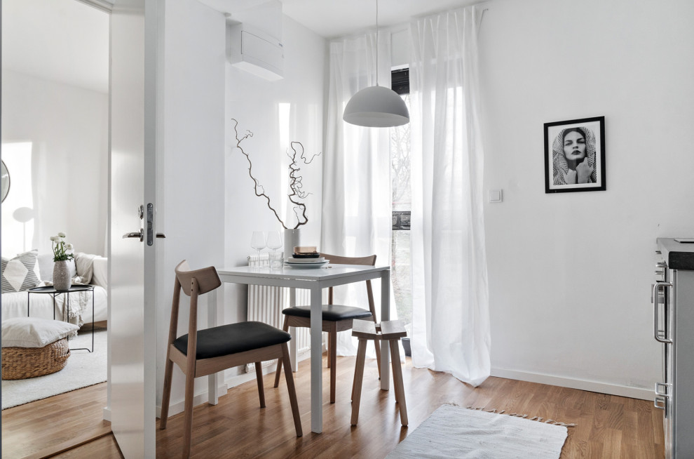 Design ideas for a small scandinavian kitchen/dining room in Stockholm with white walls, medium hardwood flooring and beige floors.
