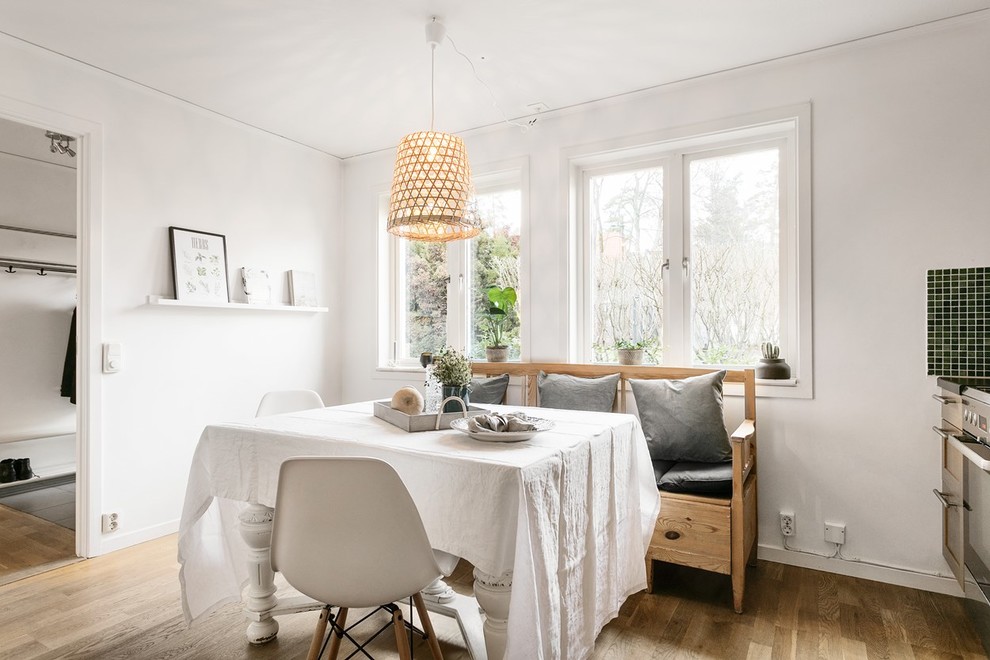 Foto på ett skandinaviskt kök med matplats, med mellanmörkt trägolv, brunt golv och vita väggar
