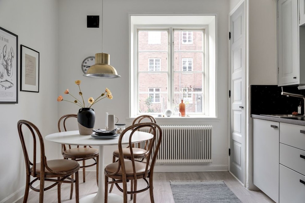 Exempel på ett minimalistiskt kök med matplats, med vita väggar, ljust trägolv och grått golv