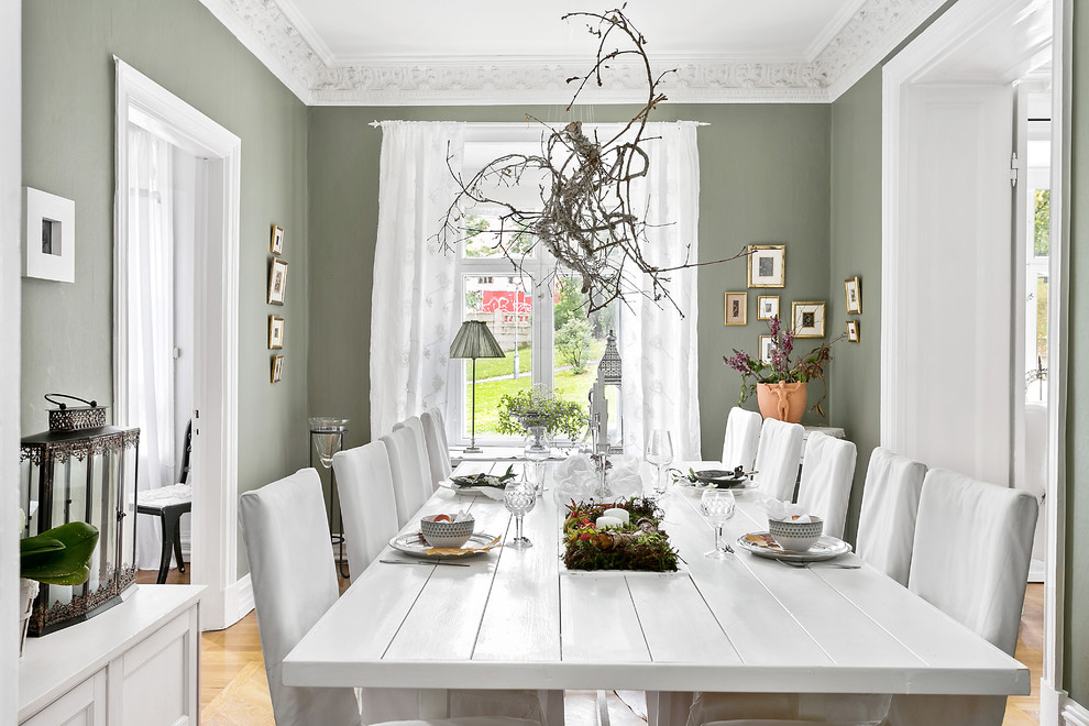 Ispirazione per una sala da pranzo scandinava di medie dimensioni con pareti verdi e pavimento in legno massello medio