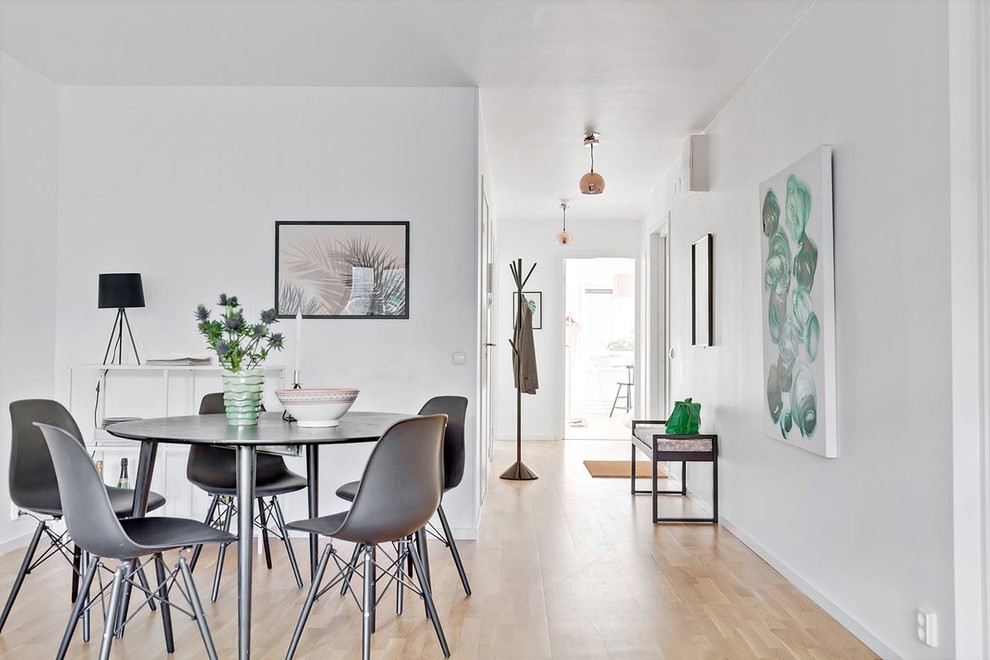 Medium sized scandinavian open plan dining room in Malmo with white walls, light hardwood flooring, no fireplace and beige floors.