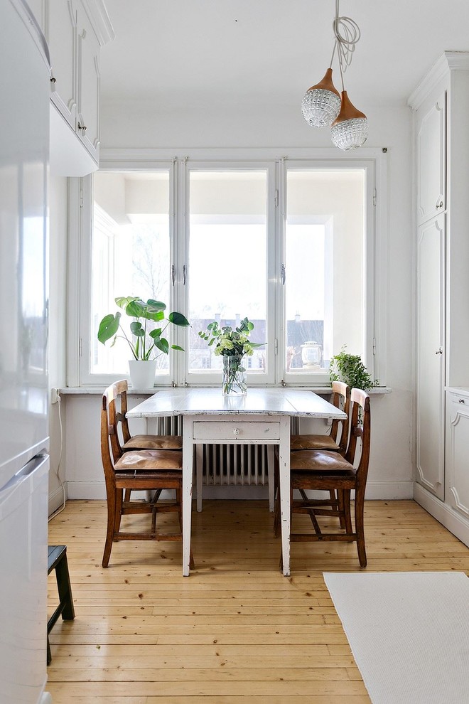 Exempel på en mellanstor skandinavisk matplats, med vita väggar och ljust trägolv