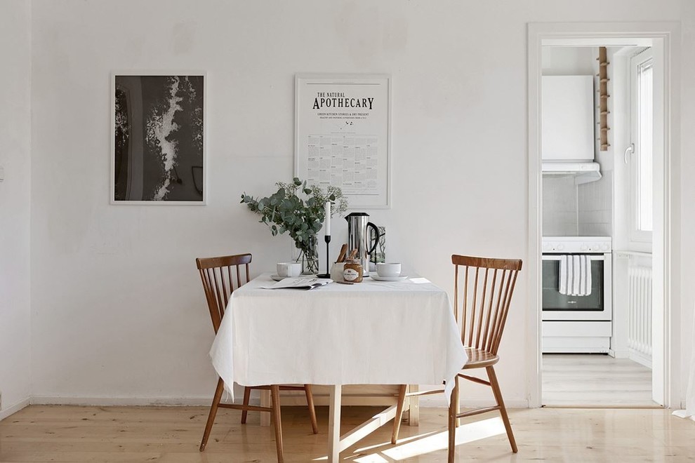Immagine di una piccola sala da pranzo scandinava con pareti bianche, pavimento in legno massello medio e pavimento beige