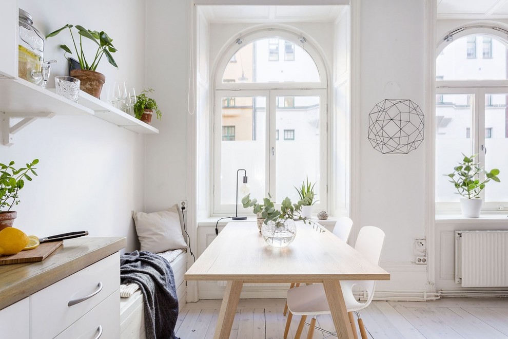 Exemple d'une salle à manger ouverte sur la cuisine scandinave avec un mur blanc, parquet clair et aucune cheminée.