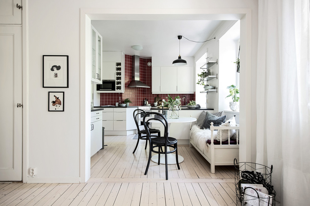 Mittelgroße Nordische Wohnküche mit roter Wandfarbe, hellem Holzboden und beigem Boden in Göteborg