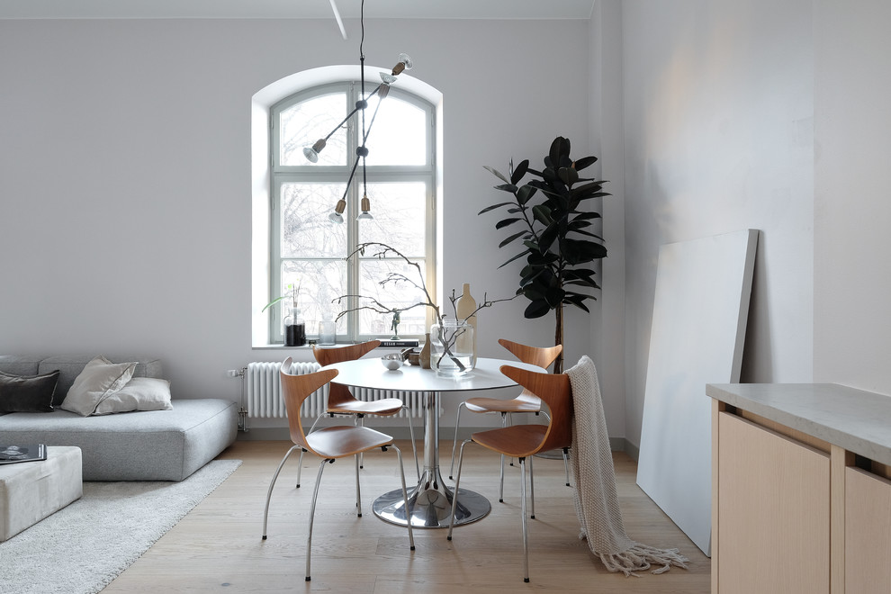 Imagen de comedor escandinavo grande abierto con paredes grises y suelo de madera clara