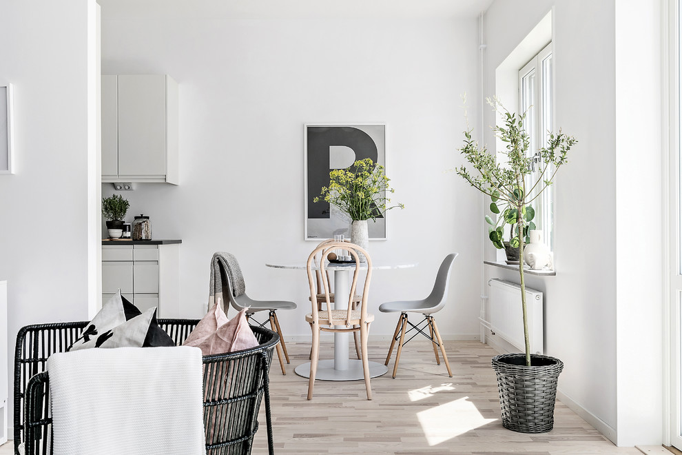 Idee per una sala da pranzo nordica con pareti bianche, parquet chiaro e pavimento beige