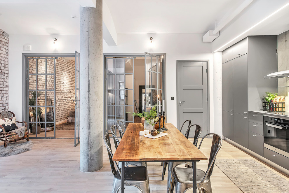 Cette image montre une grande salle à manger ouverte sur le salon urbaine avec un mur blanc, parquet clair et aucune cheminée.