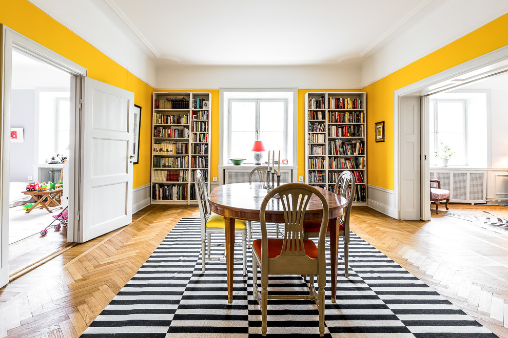 Источник вдохновения для домашнего уюта: большая гостиная-столовая в скандинавском стиле с желтыми стенами и паркетным полом среднего тона